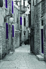 Fotografia czarno-biała uliczka z fioletowymi akcentami