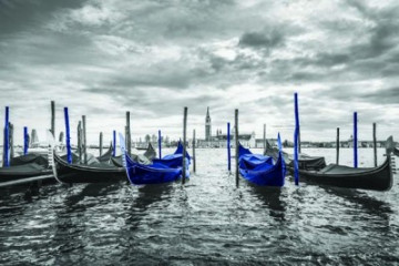 Fotografia czarno-biała z niebieskimi łódkami