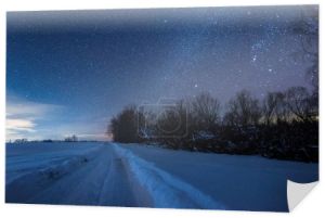 gwiaździste niebo ciemne i zaśnieżonej drodze w Karpatach w nocy w zimie