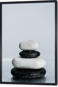 Białe i czarne kamienie zen na mokrym szkle izolowane na szarości 