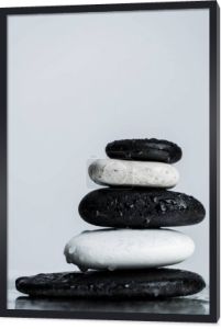 Close up widok ułożone czarno-białe kamienie zen na mokrego szkła izolowane na szarości