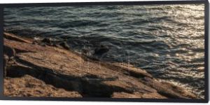 Kamienie na wybrzeżu morza podczas zachodu słońca, sztandar 