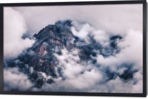Góry w chmurach w pochmurny wieczór w Nepalu. Krajobraz z pięknymi wysokimi skałami i dramatycznym zachmurzonym niebem o zachodzie słońca. Tle przyrody. Scena bajki. Niesamowite góry o zmierzchu. Zabytkowy styl