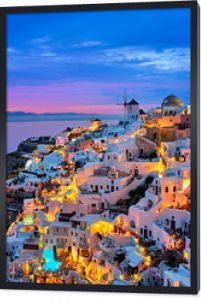 Słynne greckie kultowe selfie spot turystyczna wioska Oia z tradycyjnymi białymi domami i wiatrakami na wyspie Santorini wieczorem niebieska godzina, Grecja