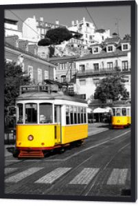 Żółty tramwaj na starych ulicach Lizbony, Alfama, Portugalia, popularna atrakcja turystyczna i miejsce docelowe. Czarno-biały obrazek z kolorowym tramwajem.