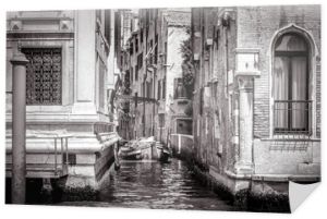 Wąska boczna ulica z łodzią w Grand Canal, Wenecja, Włochy. Zdjęcie czarno-białe.