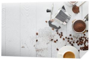 Widok z góry Gejzer ekspres do kawy w pobliżu portafilter, łyżka i filiżankę kawy na białej powierzchni drewnianej z ziaren kawy