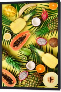 Egzotyczne owoce i liście palm tropikalnych na pastelowym żółtym tle - papaja, mango, ananas, banan, karambol, smoczy owoc, kiwi, cytryna, pomarańcza, melon, kokos, limonka. Widok z góry.