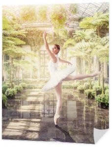 Tancerka baletowa pozuje w zielonym ogrodzie botanicznym