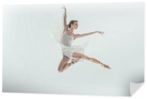 młody eleganckie baleriny w białej sukni skoki w studio, na białym tle
