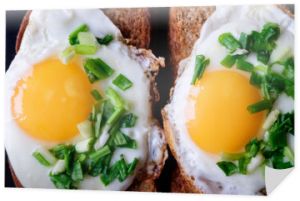 dwa jajka sadzone na chlebie z szczypiorkiem