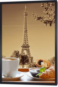 Kawa z rogalikami na tle wieży Eiffla w Paryżu, Francja