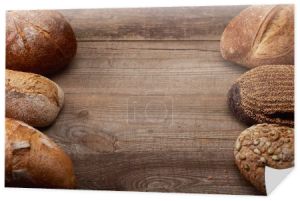 świeże bochenki chleba z pysznym chlebem na drewnianym, rustykalnym stole z kopią