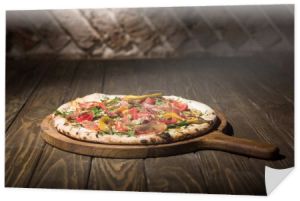 zbliżenie włoskiej pizzy na deska do krojenia na drewnianym blatem