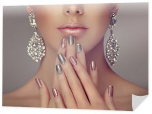 Piękny model dziewczyna z różowym i szarym srebrnym metalicznym manicure na paznokciach. Makijaż moda i kosmetyki. Duże srebrne kolczyki z brylantem.