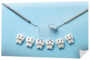 Biały ząb z próchnicy na niebieskim tle i dentysta narzędzia lustro, hak.