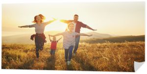 Szczęśliwa rodzina: matka, ojciec, syn i córka dzieci o zachodzie słońca