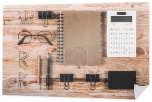 Kalkulator z okulary i materiały biurowe na stole