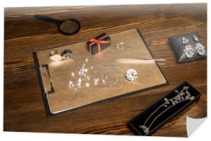 Kamienie, biżuteria i pudełko na pokładzie na drewnianym stole 