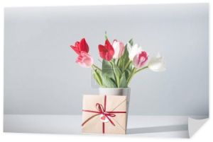 pięknych kwitnących kwiatów tulipanów w wazonie i koperty na szary