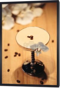 koktajl alkoholowy w metal szkło zdobione orchidei i ziarna kawy na drewnianym stole