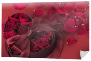 Zamknij widok róż w pudełko w kształcie serca z tasiemką i płatki na białym tle na czerwono, st Walentynki wakacje koncepcja