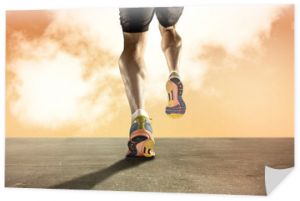 silne sportowe nogi z rozdartym mięśniem łydki młodego sportowca biegnącego po grunge asfaltowej drodze na pomarańczowym niebie o zachodzie słońca