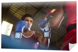 Dwóch sportowców płci męskiej walczy na ringu bokserskim