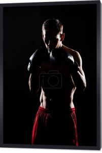 sylwetka młodego sportowca w boks rękawice bokserskie na czarnym tle