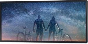 Para rowerzystów z rowery górskie w nocy pod rozgwieżdżonym niebem