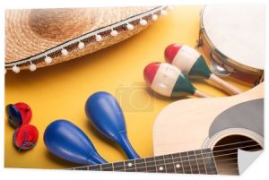 Instrumenty muzyczne i meksykańskie sombrero na żółtym tle