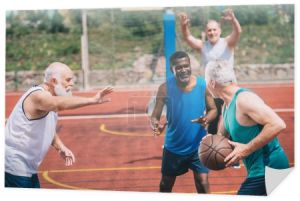 Międzyrasowe starszych sportowców razem gry w koszykówkę na plac zabaw