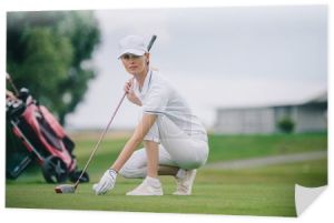 gracz w golfa kobiet w WPR i golf rękawiczki wprowadzenie piłki na zielony trawnik na polu golfowym