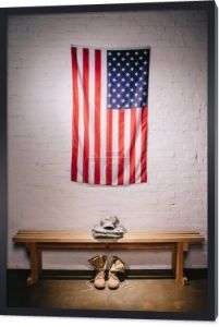 Widok z amerykańską flagę, wiszące na ścianie biały cegła i ułożone, wojskowy mundur na ławeczce, drewniane, z bliska