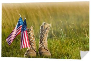 wojskowe buty w pobliżu amerykańskiej flagi z gwiazdami i paskami na trawie 