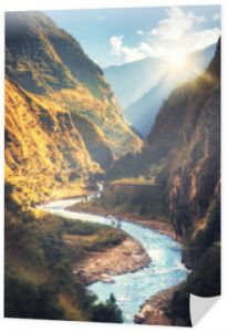 Kolorowy krajobraz z wysokimi Himalajami, piękną wijącą się rzeką, zielonym lasem, błękitnym niebem z chmurami i żółtym światłem słonecznym o zachodzie słońca jesienią w Nepalu. Dolina górska. Podróżuj po Himalajach