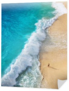 Widok człowieka na plaży na Bali, Indonezja. Wakacje i przygoda. Widok z góry z drona na plaży, lazurowe morze i relaks człowieka. Podróżuj i odpoczywaj - obraz