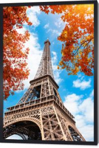 Wieża Eiffla na tle błękitnego nieba i drzew jesienią w Paryżu, Francja. Znany cel podróży travel