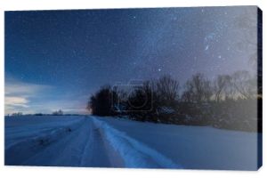 gwiaździste niebo ciemne i zaśnieżonej drodze w Karpatach w nocy w zimie