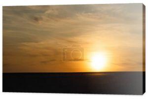 ciemna piaszczysta plaża przed jasnym słońcem podczas zachodu słońca