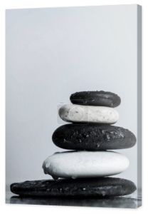 Close up widok ułożone czarno-białe kamienie zen na mokrego szkła izolowane na szarości
