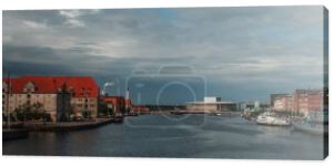 Poziomy obraz budynków w pobliżu kanału i łodzi w porcie z zachmurzonym niebem na tle w Kopenhadze, Dania 