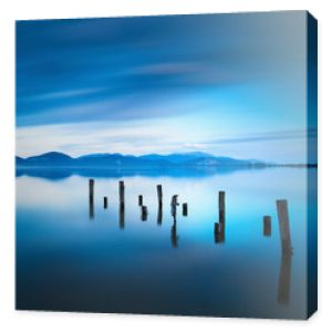 Drewniane molo lub molo pozostaje na niebieskim jeziorze zachód słońca i niebo odbicie na wodzie. Versilia Toskania, Włochy