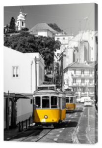 Żółty tramwaj na starych ulicach Lizbony, Alfama, Portugalia. Czarno-biały obrazek z kolorowym tramwajem.