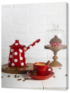 Czerwona filiżanka kawy i dzbanek do kawy na białym stole