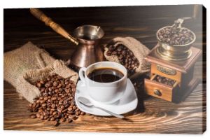 wysoki kąt widzenia filiżankę kawy z rocznika cezve i młynek do kawy na rustykalne drewniany stół rozlany z palonych ziaren