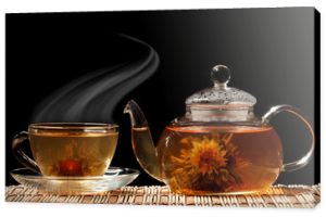 Szklany czajniczek i filiżanka zielonej herbaty na czarnym tle