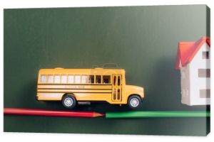 widok z góry autobusu szkolnego i modeli domów na drodze wykonane z ołówków na zielonej tablicy