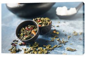 Miski zielonej suchej herbaty na tle koloru