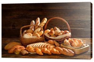 Różnorodność chleba w wiklinowym koszu na stare drewniane tła.